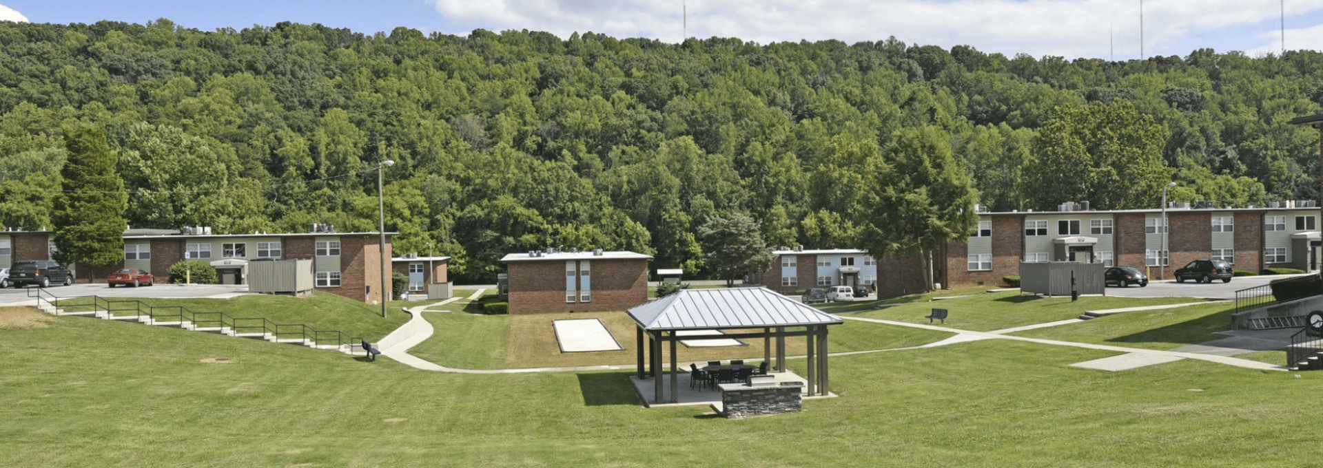 a grassy field with a picnic area and a building at The  Park At Fountain City