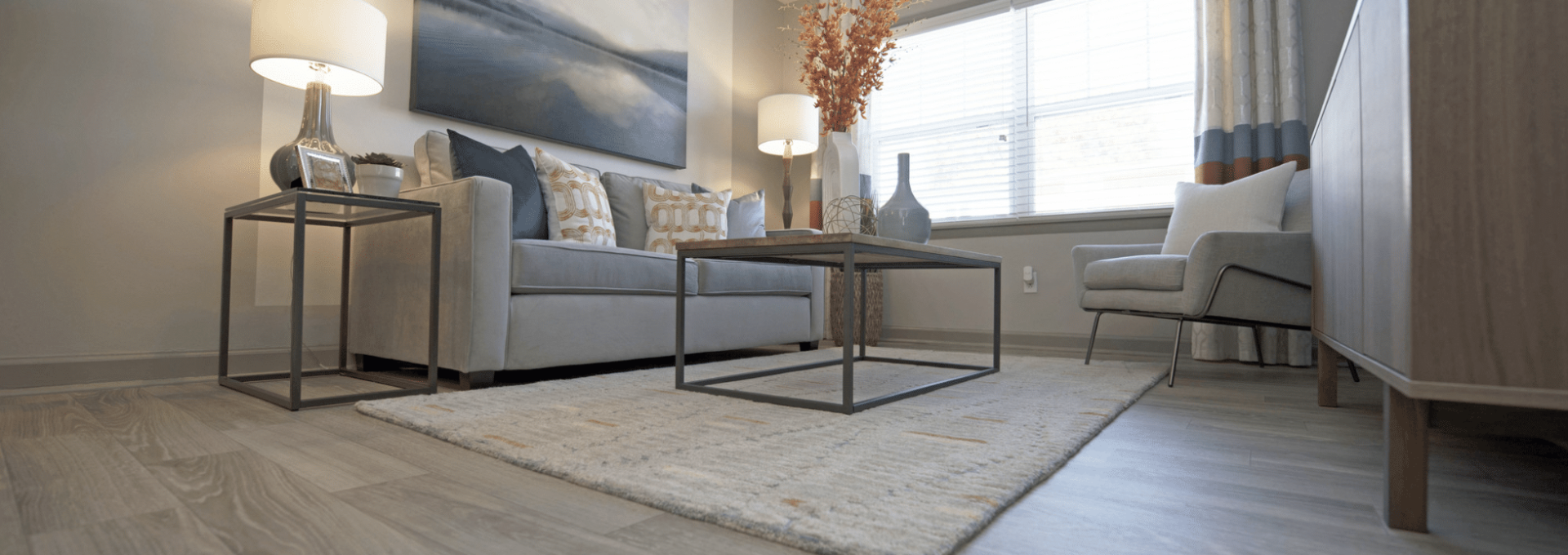 a living room with hardwood floors and a gray couch at The  Park At Fountain City